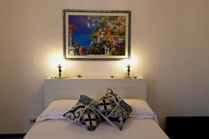 uma pintura por cima de uma cama com duas almofadas em La Ciriciccia em Acireale