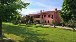 una casa grande con un césped verde delante de ella en Country House Bucaneve en Rovolon