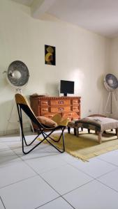 a living room with a chair and a dresser at Diadia Apartment 1 in Dakar