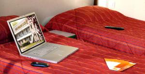 a laptop computer sitting on top of a bed at Première Classe Montluçon Saint Victor in Saint-Victor