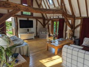 ein Wohnzimmer mit einem Sofa und einem Tisch in der Unterkunft Cosy listed barn in peaceful country village in Grandborough