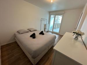バニューにあるNid confortable près de Parisのベッドルーム1室(黒い靴2本付きのベッド1台付)