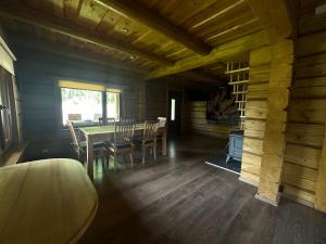 a dining room with a table and chairs in a cabin at Guest house Saulainie krasti in Saulkrasti