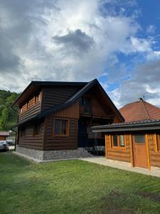 a large wooden house with a grass yard at Drevenica Skye Terchová in Terchová