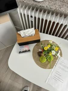 a white table with flowers on top of a radiator at Studio 1 in Bremen