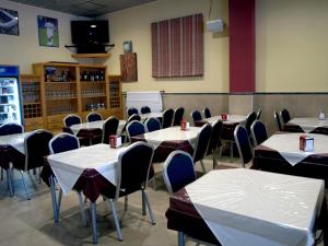 un comedor con mesas y sillas con bebidas. en Hostal la Molina, en Álora