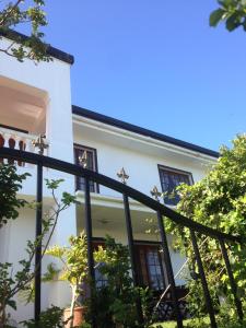 a house with a balcony and a window at Helderberg Guesthouse in Gordonʼs Bay