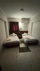 um quarto com duas camas e uma janela em Royal hotel Tanta - فندق رويال طنطا em Tanta