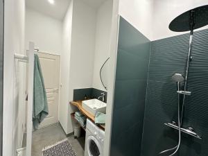 a bathroom with a sink and a washing machine at Maison de vacances in Gondrin +17 photos