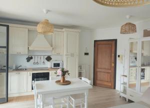 a kitchen with a white table and white cabinets at Incantevole Appartamento Monolocale Alba 2 in Alba