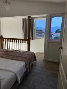 a bedroom with a bed and two windows and a door at House with big terrace near the beach in Kotor