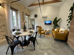a living room with a table and chairs at Maison de vacances in Gondrin