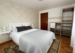 桑塔納的住宿－Vivenda Ferreira，卧室配有一张带黑色枕头的白色床