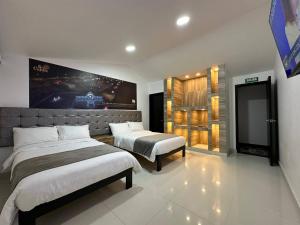 a bedroom with two beds and a tv in it at Hotel Soy Caribe in Bogotá