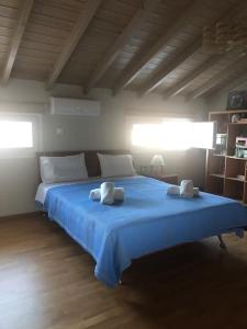 a bedroom with a blue bed with two towels on it at Modern house by the sea in Apidias Lakos