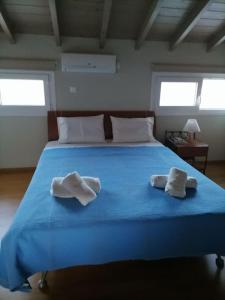 a blue bed with two towels on top of it at Modern house by the sea in Apidias Lakos
