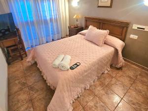 1 dormitorio con 1 cama con 2 toallas en HOSTAL JJ salduero en Salduero