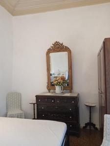 a bedroom with a dresser with a mirror and a bed at Marthas Traditional House in Symi