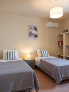 a bedroom with two beds and a lamp at Trip's House: εξοχικό σπίτι με θέα στη θάλασσα. in Ambelas