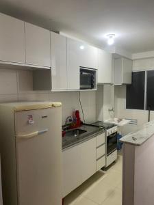 a kitchen with white cabinets and a refrigerator at Milenium residence 206 in Juiz de Fora
