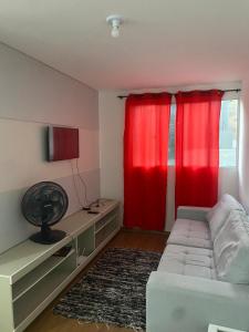 a bedroom with red curtains and a bed with a rug at Milenium residence 206 in Juiz de Fora