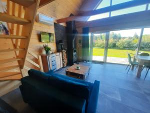 a living room with a blue couch and a table at Domek przy lesie na Roztoczu in AdamÃ³w