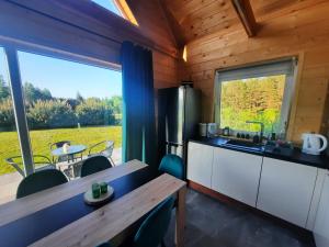 a kitchen with a table and a large window at Domek przy lesie na Roztoczu in AdamÃ³w +21 photos