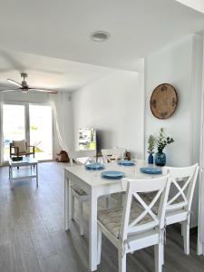 un comedor blanco con una mesa y sillas blancas en Casa con Piscina a 500m Playa en Zahara de los Atunes