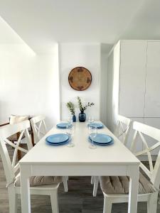 a white dining room table with plates and wine glasses at Casa con Piscina a 500m Playa in Zahara de los Atunes