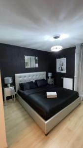 - une chambre noire avec un grand lit dans l'établissement Suite jacuzzi "spa privatif " appartement Jacuzzi, à Toulouse