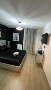 a bedroom with a black bed and a television at Suite jacuzzi "spa privatif " appartement Jacuzzi in Toulouse