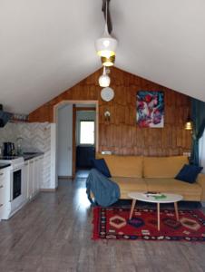 ein Wohnzimmer mit einem Sofa und einem Tisch in der Unterkunft gonta cottage in Slawske
