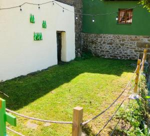 einen Hof mit einem Zaun vor einem Gebäude in der Unterkunft La So Casa -En el corazón de Asturias in Armiello