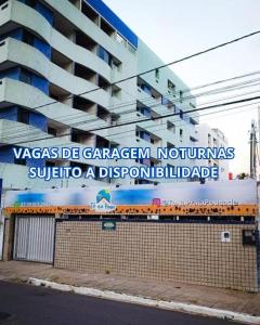 a building with a sign on the side of it at Pousada Tô na Praia! - 1ª Filial da Tô em Casa em Cabo Branco in João Pessoa