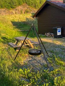 a picnic table and a basket in a yard at Apartment-B near Etne-Odda in Etnesjøen