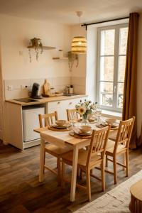 a kitchen with a wooden table with chairs and a dining room at La halte ducale #1 in Charleville-Mézières