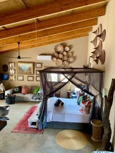 a bedroom with a bed and a living room at Rooibos Luxury Bush Cottage in Hoedspruit