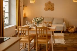 a dining room with a table and chairs and a couch at La halte ducale #1 in Charleville-Mézières +5 photos