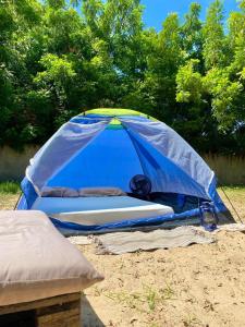 uma tenda azul sentada no chão na areia em Canoa Roots Hostel & Camping em Canoa Quebrada