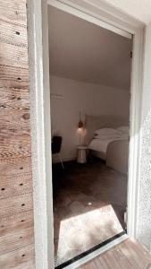 a door to a bedroom with a bed in a room at La Bâtisse en Blanc in Golfe-Juan