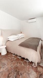 a bedroom with a bed with a brown blanket at La Bâtisse en Blanc in Golfe-Juan