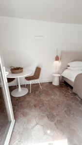 a bedroom with a table and a bed and a table and chair at La Bâtisse en Blanc in Golfe-Juan