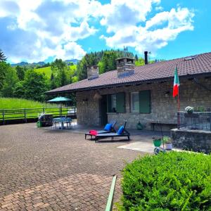 ein Steinhaus mit einer Terrasse mit Möbeln und einer Flagge in der Unterkunft La Casa di Angi in Onore