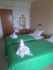 Dos camas en una habitación con toallas. en Marinos Studios at Lourdata village, en Lourdata