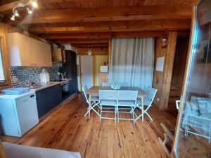 a kitchen and dining room with a table and chairs at CHALET 9 "Pensée" in Garin