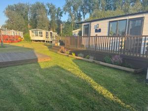 a large yard with a house and a rv at Beautiful caravan on Billing Aquadrome in Northampton