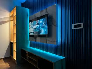 TV de pantalla plana en una pared azul en Blue Star Apartments, en Ulcinj