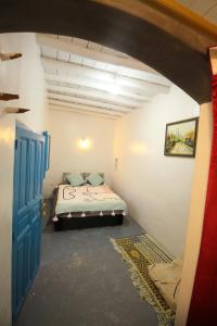 um quarto com uma cama e uma porta azul em ASARAG em Mirleft
