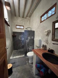 a bathroom with a shower and a toilet and a sink at Bahari Beach Bungalows in Jambiani