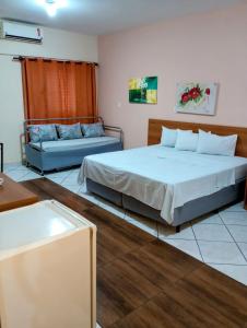 Großes Zimmer mit 2 Betten und einem Sofa in der Unterkunft Calabreza Hotel e Restaurante - By UP Hotel in Três Corações